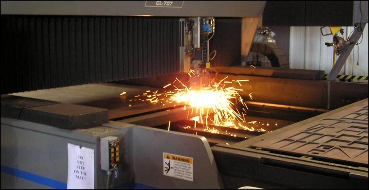A plasma burning machine etching a metal sheet.