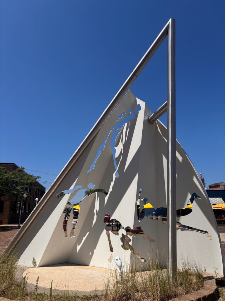 An angular sculpture constructed of steel piping and other materials.